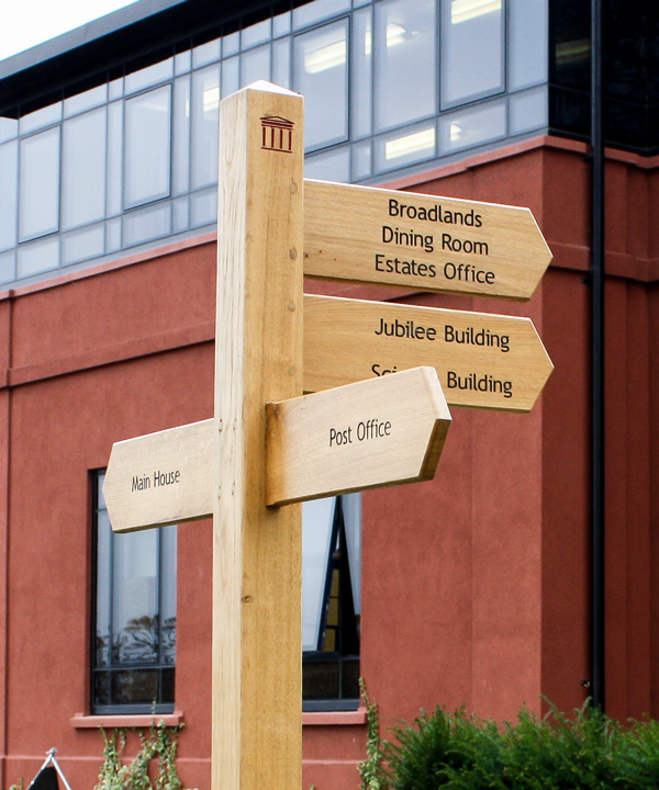 Wooden Fingerpost Sign with wide arms, black infilled lettering and custom post logo.